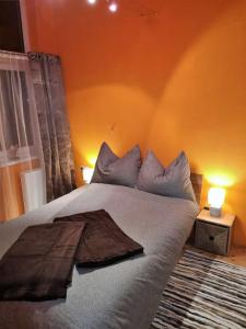a bed in a bedroom with an orange wall at Dachgeschosswohnung am Waldrand in Arzl im Pitztal