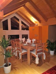 a dining room with a wooden table and chairs at Dachgeschosswohnung am Waldrand in Arzl im Pitztal