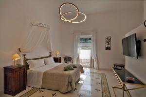 ein Schlafzimmer mit einem großen Bett und einem Kronleuchter in der Unterkunft Palazzo Rollo in Lecce