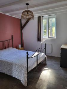 Cottage cosy à la campagne في Queyssac: غرفة نوم بسرير وثريا