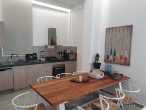 eine Küche mit einem Holztisch und Stühlen in der Unterkunft Isalos Seafront Villa I Sea fragrance in Chania
