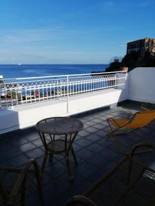 uma varanda com uma mesa e cadeiras e o oceano em Casa del Vento em Lipari