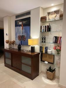 a room with a desk with a lamp and shelves at ALCAZABA beach in Estepona