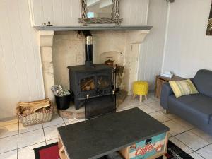 a living room with a stove and a couch at Swift Gites Creuse 