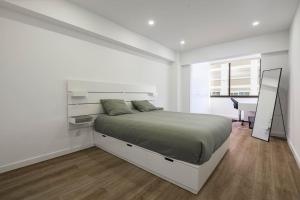 Apartamento Magnifico em Oeiras في باكو دي أركوس: غرفة نوم بيضاء مع سرير كبير ومكتب
