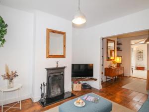a living room with a fireplace and a television at Owl's Rest in Weymouth