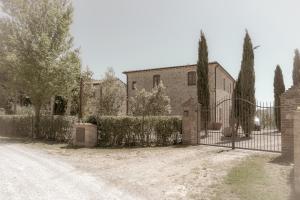 una puerta frente a una casa con árboles en Villa Borgo Pian di Sala en San Gimignano