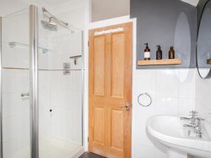 a bathroom with a shower and a sink and a wooden door at Owl's Rest in Weymouth +25 photos