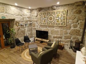 a living room with a stone wall at Quinta da Casa dos Santos - Inside Gerês in Geres