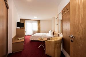 フルプメスにあるHotel Medrazerhofのベッドとテーブルが備わるホテルルームです。
