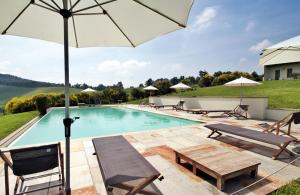 a swimming pool with a table and an umbrella at Prime Alture Wine Resort in Casteggio