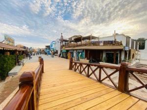 a wooden boardwalk with a wooden fence and buildings at Neptune Hotel in Dahab