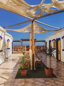 a patio with a tent and potted plants at Neptune Hotel in Dahab