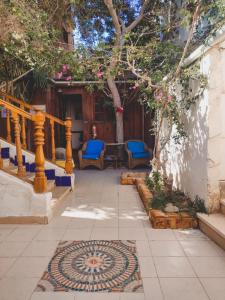 a patio with blue chairs and a table and a tree at Neptune Hotel in Dahab