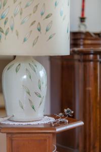un vase blanc assis sur une table à côté d'une lampe dans l'établissement Apartment Fabris, à Split