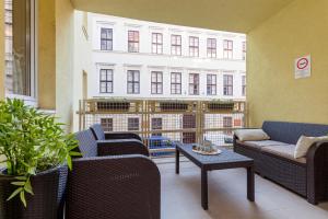 einen Balkon mit Stühlen, einem Tisch und einem Gebäude in der Unterkunft GDE Holló Apartments in Budapest