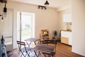 Duas mesas e cadeiras num quarto com uma cozinha em Olio su Tela em Paliano