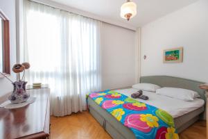 a bedroom with a bed with a colorful blanket at Apartment Fabris in Split