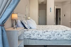 a bedroom with a bed and a lamp on a dresser at LA CRETE SANDS NO 7 in Uvongo Beach