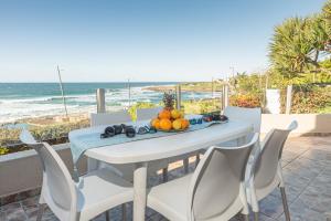 a table and chairs with a plate of fruit on it at LA CRETE SANDS NO 7 in Uvongo Beach +9 photos