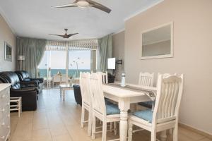a dining room and living room with a table and chairs at LA CRETE SANDS NO 7 in Uvongo Beach