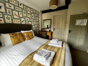 een slaapkamer met een bed met handdoeken erop bij The Red Lion in Northampton