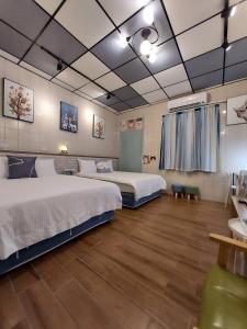 1 dormitorio con 2 camas y suelo de madera en 鹿鹿咪民宿, en Lukang