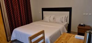 a bedroom with a bed with white sheets and pillows at Traveller's StaY in Kigali