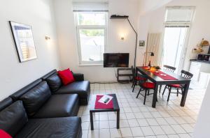 uma sala de estar com um sofá de couro preto e uma mesa em Haus Albatros em Timmendorfer Strand