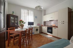 cocina con mesa y sillas y cocina con microondas en B&B Il Tempo Del Vento-Camere e Appartamenti, en Tresana