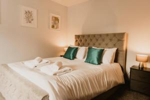 Schlafzimmer mit einem Bett mit grünen und weißen Kissen in der Unterkunft The Sun Deck Apartment - Westbrook Bay Beach - By Goldex Coastal Breaks in Kent