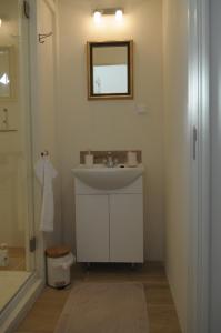 a white bathroom with a sink and a mirror at De Parel van Pekel in Nieuwe Pekela
