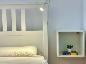 een slaapkamer met een bed met een wit hoofdeinde en een spiegel bij Grandeur in Timişoara