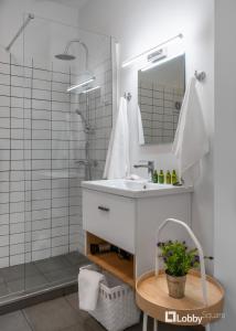 łazienka z umywalką i prysznicem z lustrem w obiekcie Aether Apartment by LobbySquare w Atenach