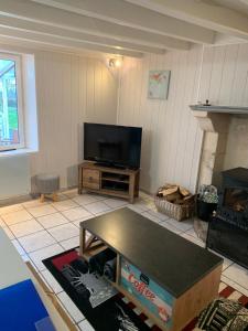 a living room with a tv and a coffee table at Swift Gites Creuse in Ventenat