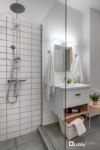 łazienka z prysznicem, umywalką i lustrem w obiekcie Aether Apartment by LobbySquare w Atenach
