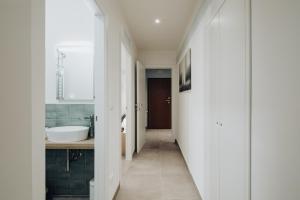 a white bathroom with a sink and a tub at Realkasa Graziella in Bologna