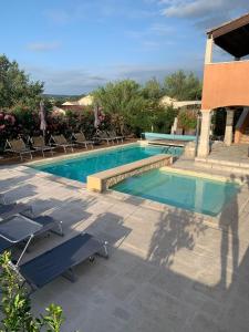 a swimming pool with two chairs at B&B La Vieille Source in Saint-Martin-dʼArdèche