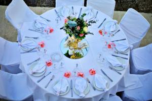 une table blanche avec des fleurs et de l'argenterie sur elle dans l'établissement Hotel Αchillion Grevena, à Grevená