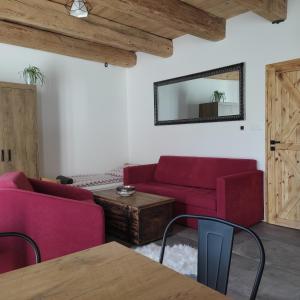 ein Wohnzimmer mit zwei roten Sofas und einem Tisch in der Unterkunft Rezidence Valcha in Sušice
