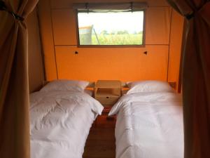 two beds in a small room with a window at Walter's Retreat in Buckingham