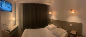 une chambre d'hôtel avec un lit et une télévision dans l'établissement Hôtel Saint Roch Montpellier Centre, à Montpellier
