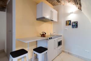 eine kleine Küche mit einer Spüle und 2 Hockern in der Unterkunft La casa dei tre pesci - Appartamento Alborella in Torno