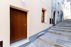 eine Tür an der Seite eines Gebäudes mit einer Treppe in der Unterkunft La casa dei tre pesci - Appartamento Alborella in Torno