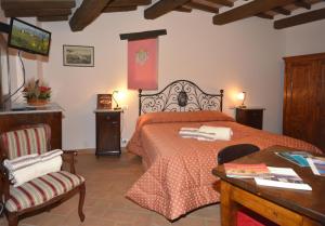 a bedroom with a bed and a table and a chair at B&B Camere La Vite in Pienza