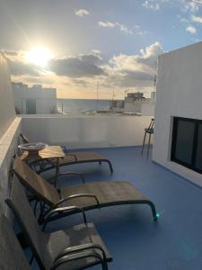 a balcony with chairs and tables and the ocean at Eterna Primavera, a 40m de la piscina natural in Punta Mujeres