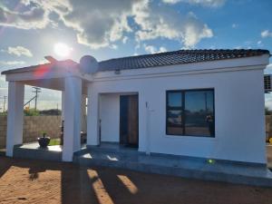 a small white house with a rainbow on the roof at Casa-Pel Guest Wing in Palatswe