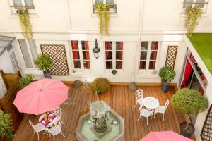widok na patio ze stołami i parasolami w obiekcie Agate Hôtel w Paryżu