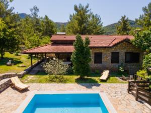 a villa with a swimming pool in front of a house at Sakin Vadi Villas in Marmaris