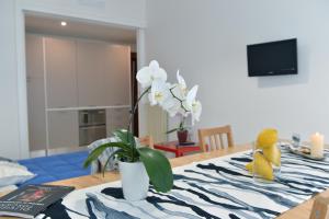 a table with a vase with white flowers on it at Tizi Apartments Corso Reginna in Maiori